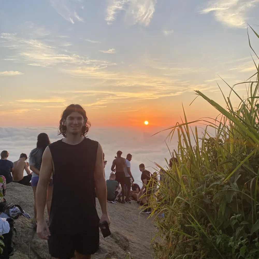 Kaya on a mountaintop at sunrise above the clouds in Rio